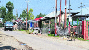 A CRPF jawan stands guard outside his camp at Shopian on Friday.