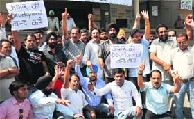 Members of the J&K Contractors Co-ordination Committee stage a protest in front of the PWD Complex in Jammu on Friday.