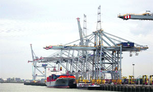 A ship is loaded with containers in the Port of Antwerp, Belgium, on Friday. Nearby, construction is on for the worlds largest ship lock, the Deurganckdock lock, which will will be as wide as a 19-lane highway.
