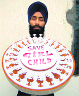  A paper artist displays a model made to spread the message for saving the girlchild in Amritsar on Saturday.