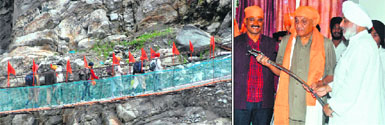(Left) The first batch of pilgrims to Hemkund Sahib crosses a bridge near Gobindghat on Saturday; (right) Narinderjit Singh Bindra, president of the Shri Hemkund Sahib committee and chairman of the Uttarakhand Minorities Commission, presents a sword to CM Vijay Bahuguna on the resumption of the yatra at Gurdwara Gobindghat in Chamoli district on Saturday.