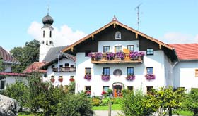A typical chalet in Tyrol with sloping wooden roofs and window boxes with flowers