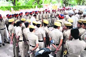 Police personnel assemble outside the bus stand before conducting the checking in Bathinda on Sunday