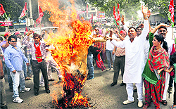 Samajwadi Party activists burn an effigy of the Central Government during a protest over the price rise in Dehradun on Sunday