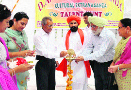 Swami Surya Dev lights the traditional lamp to inaugurate the talent hunt programme at DAV College in Bathinda on Monday. 