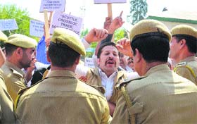 Police personnel restrain protesting cross-LoC traders in Srinagar on Monday.