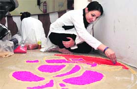 A participant creates a colourful rangoli in the painting comeptition at Jammu University on Monday.