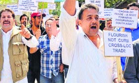 Traders raise slogans in support of cross-LoC trade in Srinagar on Monday.