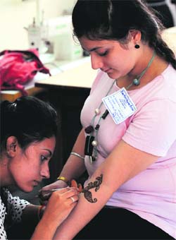 A girl takes part in the mehandi design competition during the Panjab University Zonal Youth and Heritage Festival in Ludhiana on Monday.