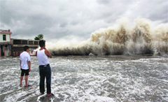 Men watch waves hit the shores as Typhoon Usagi approaches in Shantou, China, on Sunday.  Reuters