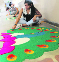 A girl makes a rangoli during a competition at MCM College in Chandigarh. A Tribune Photograph