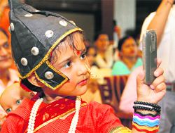 A young girl clicks photographs on a mobile phone. 