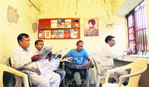 People reading newspapers in the reading room.