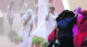 Girls run for cover during a duststorm in Ludhiana on Tuesday.
