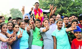 Bikramjit Singh being welcomed by his fellow players at the Ludhiana railway station.