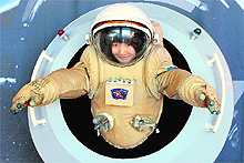 A woman tries out a space suit at the 64th International Astronautical Congress in Beijing on Tuesday