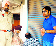 Officials of the House Tax Department of the Municipal Corporation seal a shop in Amritsar