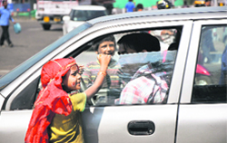 Children beg for alms from drivers at Bikram Chowk in Jammu on Wednesday. Tribune photo: Inderjeet Singh