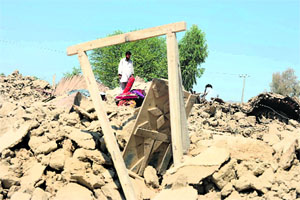 A villager looks at the rubble of destroyed houses in the quake-hit district of Awaran on Wednesday. 