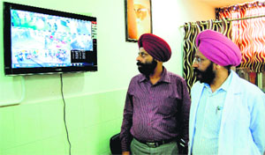 Senior Medical Officers Dr Balbir Singh Dhillon (left) and Hardeep Singh Ghai check the CCTV monitoring screen at the Jallianwala Bagh Martyrs Memorial Civil Hospital in Amritsar on Thursday.