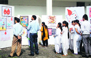 People have a look at the posters designed by students of the Sardar Bhagwan Singh PG Institute of Biomedical Sciences and Research in Dehradun on Thursday. 