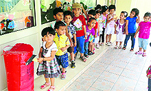 Students post handmade cards to their parents in a replica of a letterbox at Penguin Castle Preschool in Ludhiana