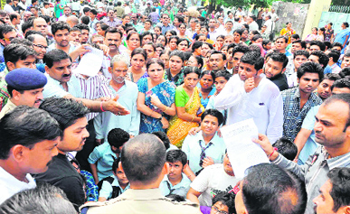 Agitated employees of St Marys School and local traders gherao Circle Officer Rajesh Bhatt in protest against the death of a class X student in Haridwar on Friday. 