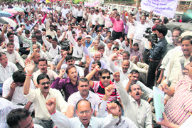 Uttarakhand government employees stage a protest outside the Secretariat in Dehradun on Friday. 