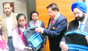 The Rotary district governor distributes school bags to needy students in Mussoorie on Friday. 