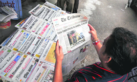 A man reads newspapers carrying reports on the twin terror strikes during a shutdown observed in Jammu on Friday.