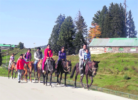 Tourists enjoy a horse ride in Gulmarg on Friday.