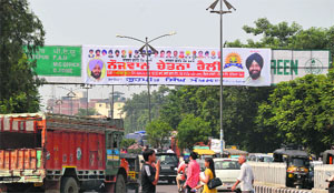 An illegal hoarding installed on a direction board near Bhai Wala Chowk in Ludhiana on Friday. 