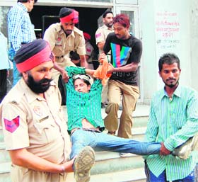 Policemen take undertrial Harjinder Singh to a hospital after he hurt himself while escaping from the police coustody at the district court complex in Amritsar on Saturday.