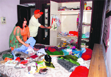 A couple looks at a ransacked room of the house in Sector 11, Panchkula, on Saturday. 