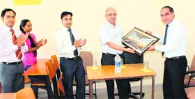 Dr Subodh Chaudhary gives a memento to Prof SC Bagri, Vice-Chancellor of Himgiri Zee University, in Dehradun on Friday.