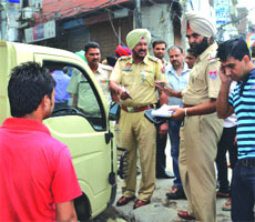 Policemen issue challans in Ludhiana on Saturday. 