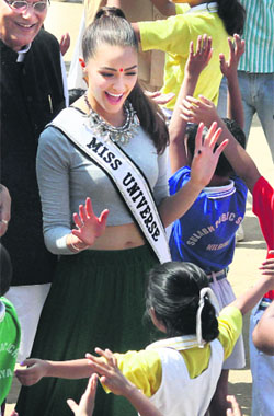 Miss Universe Olivia Culpo dances with children during a visit to a school in New Delhi on Saturday.