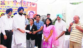 Parul Gupta, a hearing impaired tennis player, receives a cash prize of Rs 1 lakh from Bikramjeet Singh Majithia, Revenue Minister of Punjab, at a ceremony in Patiala. Parul represented the nation in the recently held 22nd Deaflympics at Sofia in Bulgaria