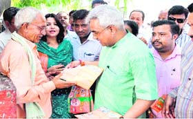 Vice-President of the state unit of the BJP Madan Kaushik distribute pamphlets among local residents criticising the Congress-led governments in Haridwar on Sunday