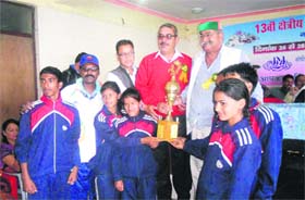Manmohan Singh Mall, Municipal Council president, presents the trophy to the winners of the 13th regional athletics meet in Mussoorie on Sunday