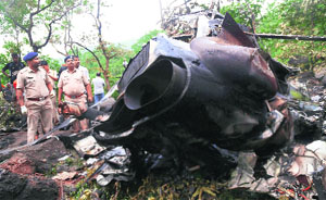 Policemen search for survivors in the debris of a crashed helicopter near Murbad village in Thane on Sunday.