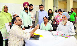 An expert examines the X-ray scan of a patient at a cancer detection camp in Ludhiana on Sunday