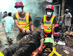 Pakistani rescue workers remove the body of a blast victim in Peshawar on Sunday.