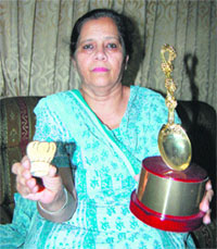 Satpal Kaur shows the trophy she won in the Sanjeev Kapoor Ke Kitchen Khiladi, in Amritsar. 