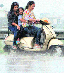 A woman, along with her daughters, caught in rain in Amritsar on Monday.