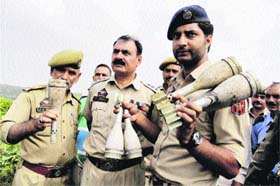 An Army officer with a policeman holding the scrap of a mortar shell found in an industrial area near Bari Brahmina during a search operation in Jammu on Monday
