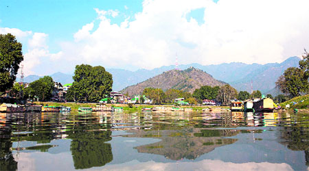 Waters of the Jhelum produce a reflection of mountains, trees and other structures in Srinagar on Monday.