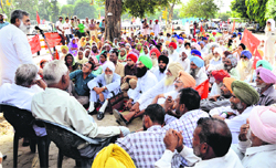 A farmer leader addresses a gathering during the protest outside the DC office in Ludhiana on Monday