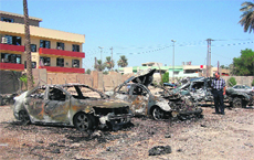 A man looks at damaged vehicles at the site of a car bomb attack in Baghdad on Monday. 