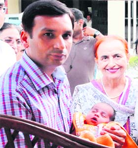 Deputy Commissioner Ravi Bhagar with the newborn girl left in Panghura at Red Cross Bhavan in Amritsar on Tuesday